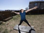 Kara Winger uses a cable system to simulate throwing a javelin as she trains outside her home in Colorado Springs, Colo., Wednesday, April 29, 2020. The renovated home of three-time Olympic javelin thrower Kara Winger now has all the training amenities she needs, including cable. No premium channels on this cable. It&#039;s just a basic wire she and her husband installed in the backyard to help her work on her technique. She throws a metal pipe along the angled cable to simulate javelin tosses.