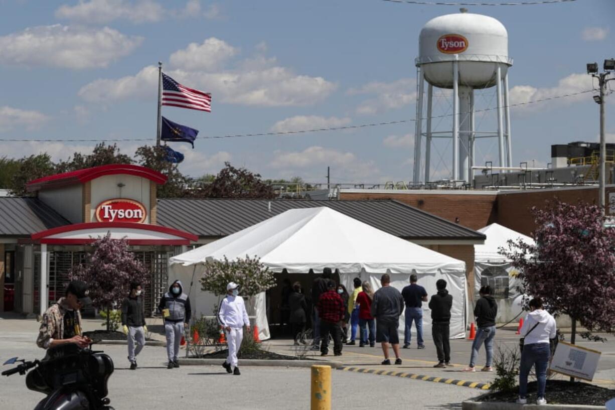 Workers line up to enter the Tyson Foods pork processing plant in Logansport, Ind., Thursday, May 7, 2020. In Cass County, home to the Tyson plant, confirmed coronavirus cases have surpassed 1,500. That&#039;s given the county -- home to about 38,000 residents -- one of the nation&#039;s highest per-capita infection rates.