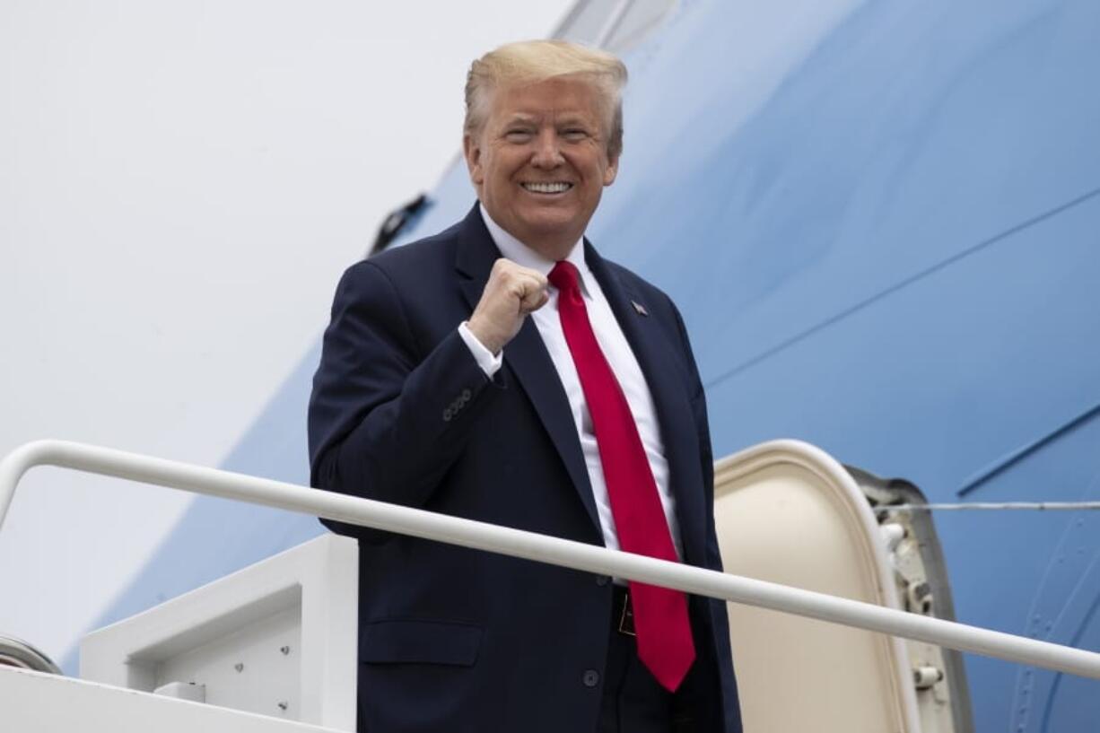 President Donald Trump pumps his fist while boarding Air Force One as he departs Thursday, May 21, 2020, at Andrews Air Force Base, Md. Trump will visit a Ypsilanti, Mich., Ford plant that has been converted to making personal protection and medical equipment.