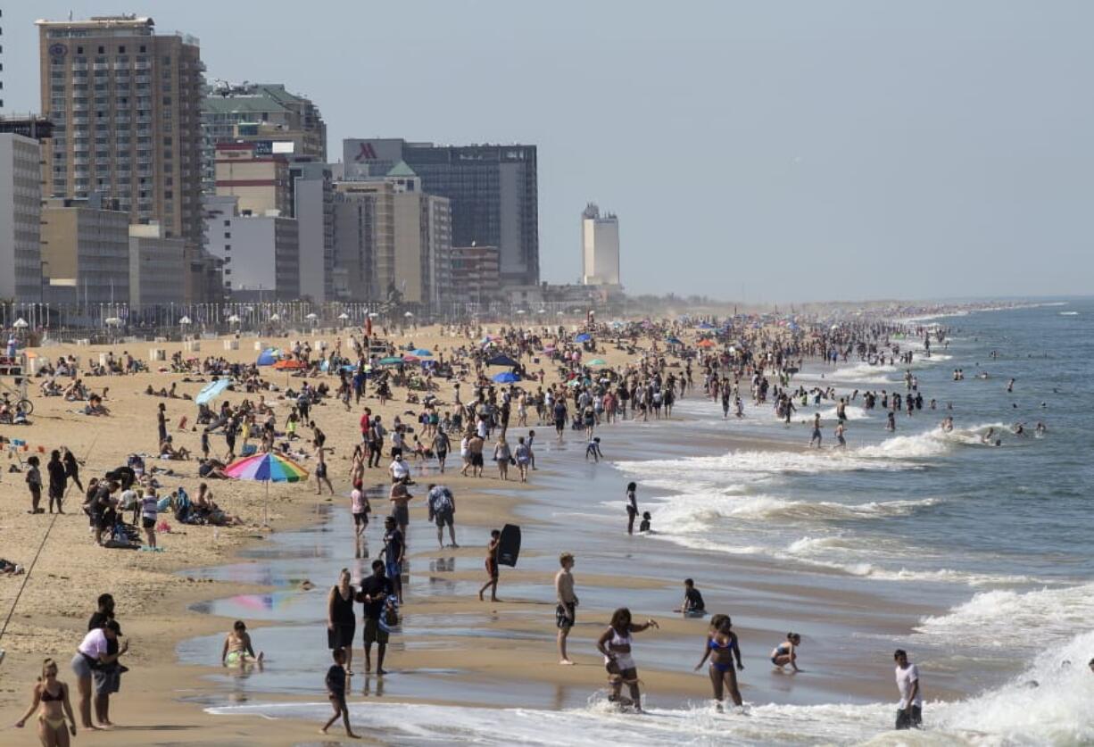 Warm weather draws crowds to the oceanfront, Saturday in Virginia Beach, Va.