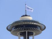 A flag promoting the All In WA relief effort flies Wednesday atop the Space Needle in Seattle. Southwest Washington is participating in the statewide campaign aimed at helping people impacted by the COVID-19 pandemic. (Ted S.