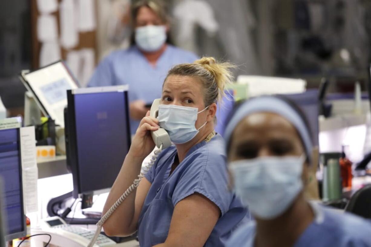 FILE - In this May 8, 2020, file photo, registered nurse Katie Hammond looks up as she talks on the phone in the COVID-19 Intensive Care Unit at Harborview Medical Center, which is part of Seattle-area health care system UW Medicine, in Seattle. UW Medicine, which has played a leading role in responding to the coronavirus outbreak, is now facing a huge financial hole because of the fallout from COVID-19. The Seattle Times reports UW Medicine&#039;s losses could be more than $500 million by the end of the summer.