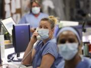 FILE - In this May 8, 2020, file photo, registered nurse Katie Hammond looks up as she talks on the phone in the COVID-19 Intensive Care Unit at Harborview Medical Center, which is part of Seattle-area health care system UW Medicine, in Seattle. UW Medicine, which has played a leading role in responding to the coronavirus outbreak, is now facing a huge financial hole because of the fallout from COVID-19. The Seattle Times reports UW Medicine&#039;s losses could be more than $500 million by the end of the summer.