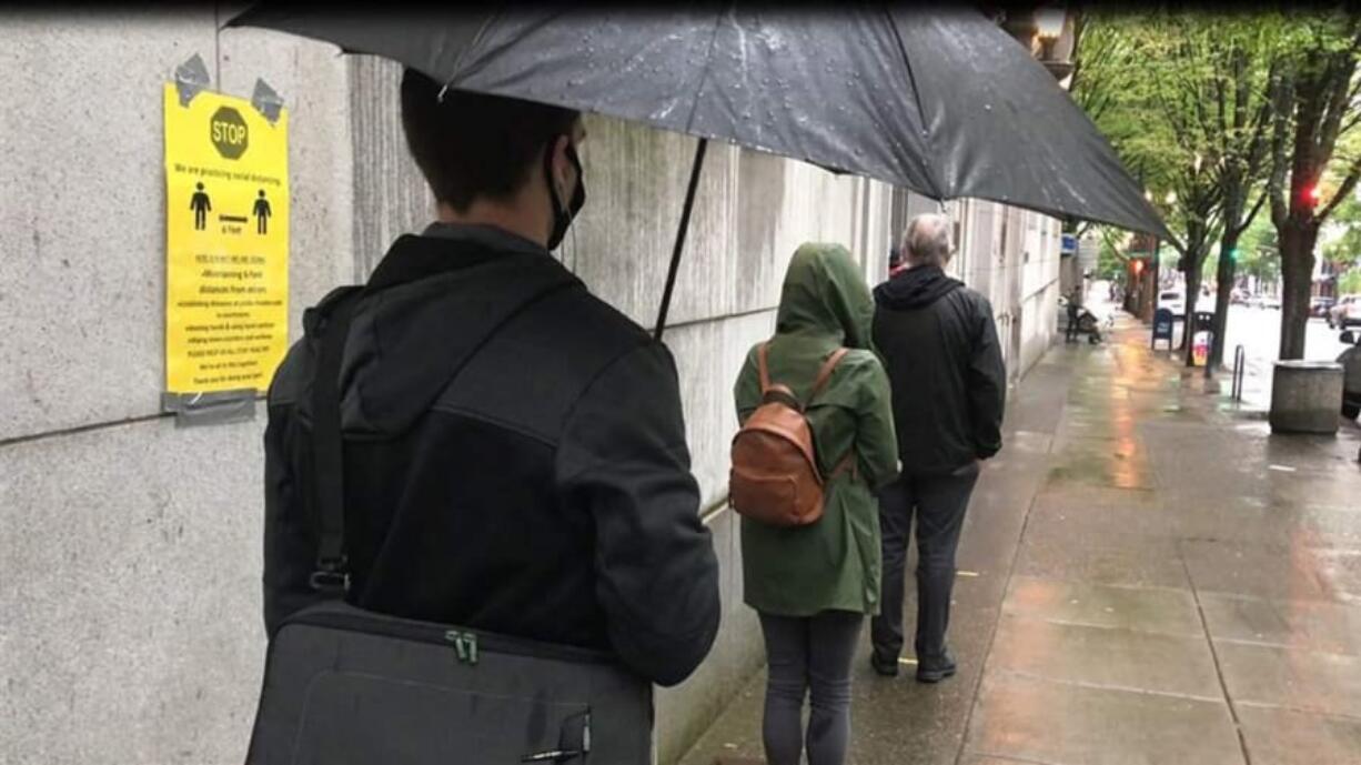 Potential grand jurors wait 6 feet apart to enter the Multnomah County Courthouse in Portland in May 2020. Courts around the U.S. must figure out how to resume operations in a way that keeps employees and visitors safe.