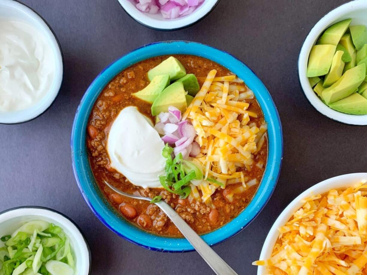 Lots of crunchy, sharp and creamy toppings turn a simple bowl of beef and chili into dinner in an instant.