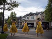 Mahealani Mackenzie, 20, left, Maile Taute, 16, Ellie Buss, 15, and Amaya Yoshinobu, 14, perform hula during a driveway concert in front of Kaloku Holt&#039;s home in Whipple Creek.