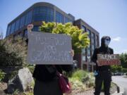 Demonstrators who declined to be identified protest against the death of George Floyd and other unarmed black men and women outside Vancouver City Hall on Monday. The gathering marked downtown Vancouver&#039;s second small protest in two days, as people across the country speak out en masse against institutional racism and police brutality.