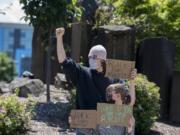 Demonstrators who declined to be identified protest against the death of George Floyd outside Vancouver City Hall on Monday.