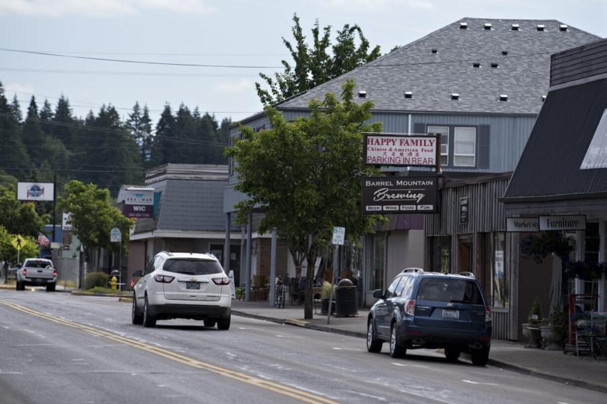 A motorist passes by empty sidewalks in downtown Battle Ground on Wednesday morning. The city is preparing for the economic impact of the COVID-19 pandemic that has affected businesses.