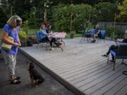 Laura Kok feeds her daughter&#039;s dog Zero as the family enjoys dinner together outside their home in Vancouver earlier this month. Since the pandemic stay-home orders were issued in March, the family has been coming together in Laura and Jeroen Kok&#039;s backyard for a socially distanced dinner at least once a week. Their youngest daughter, who lives out of town, joins via an online video call.