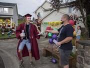 Prairie High School graduate David Hatcher, 18, left, celebrates his accomplishments with Victor Paskar on Friday evening during a neighborhood graduation ceremony for the class of 2020 in Orchards. The students marked the occasion with a cul-de-sac graduation with nearby families as COVID-19 concerns forced the cancellation of their scheduled in-person ceremonies.