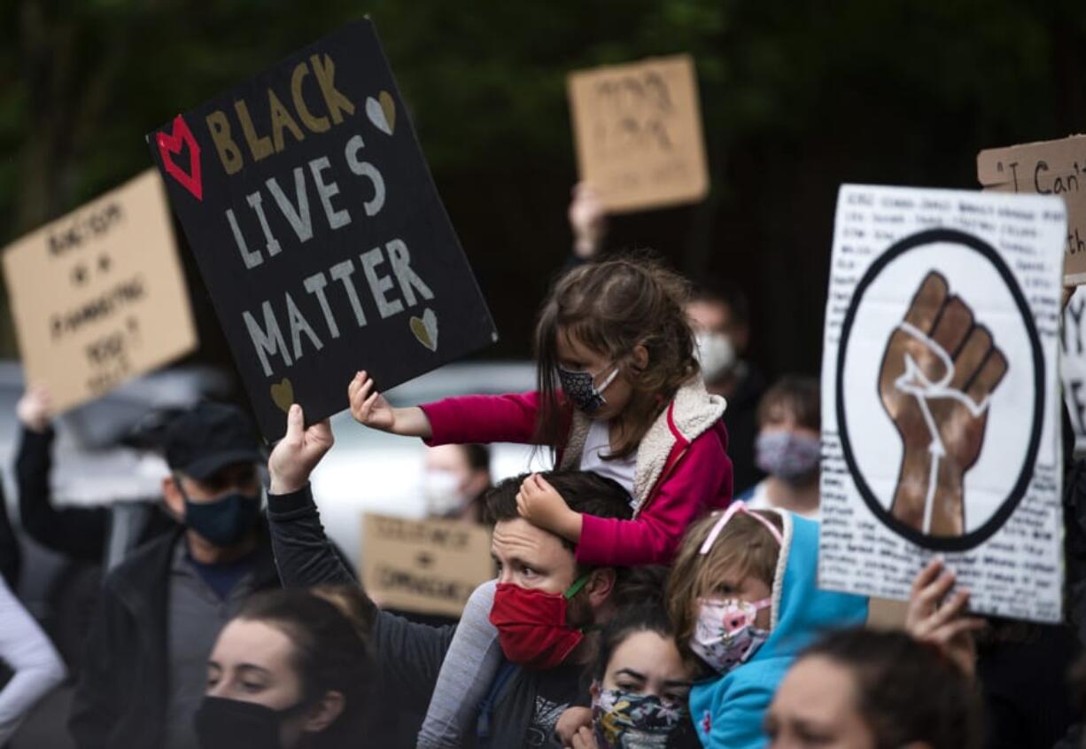 Clementine Tomerlin, 5, helps her dad, Clay, hold up a sign as they join hundreds of people for a rally and peaceful protest at the Clark County Courthouse on June 5.