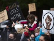 Clementine Tomerlin, 5, helps her dad, Clay, hold up a sign as they join hundreds of people for a rally and peaceful protest at the Clark County Courthouse on June 5.