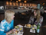 Laura Jhaveri, left, of Ridgefield enjoys lunch with Tamisha Dunn of Portland at Twigs Bistro at The Waterfront Vancouver. Some Clark County restaurants including Twigs reopened for dine-in service on Friday and have seen lots of customers since.