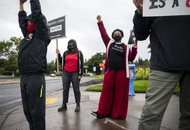 Jack Curtis of Vancouver, 10, left, and Mill Plain Elementary School first grader teachers Corinne Contreras, center, and Carmela Lemon, right, join the Black Lives Matter Rally Day of Action organized by the Washington Education AssociationÕs statewide day of events in Vancouver on June 12, 2020.