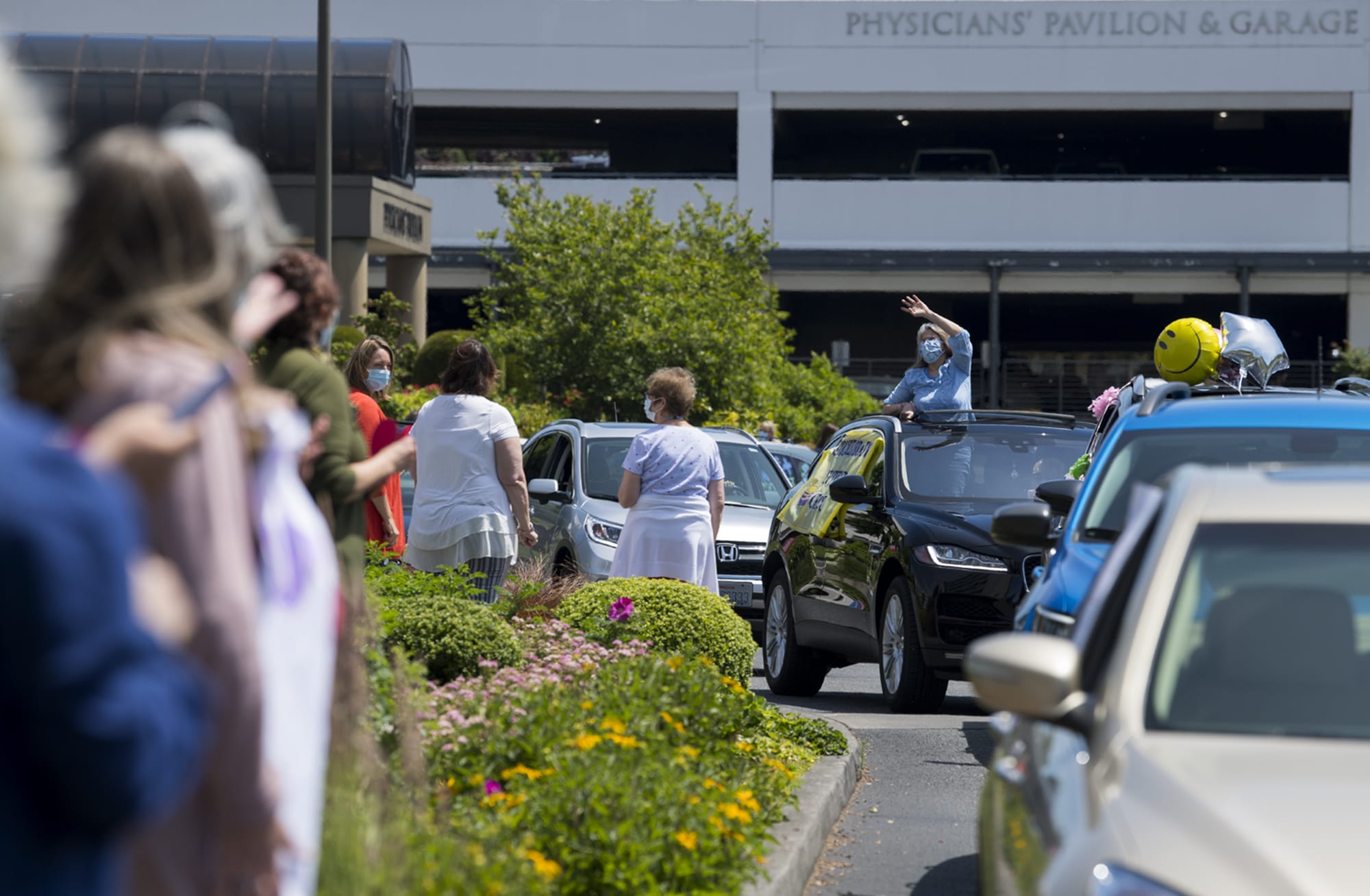 Vivian DiGioia of the stroke/brain support group, center in blue, greets hospital staff during a motorcade welcoming back volunteers at PeaceHealth Southwest Medical Center on Thursday afternoon, June 18, 2020. Around 40 volunteers, who have been furloughed since March 18, came out for the warm welcome back.