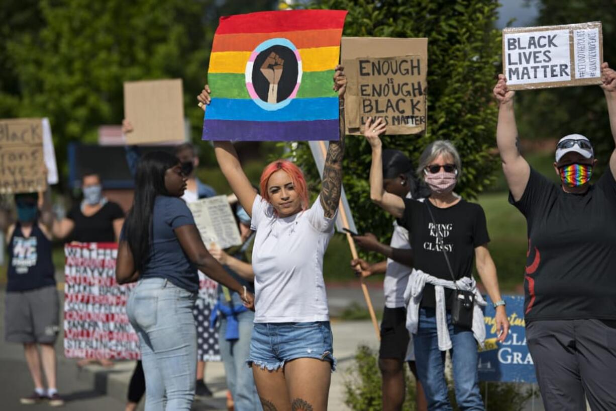 Kaitlyn Bruneau of Vancouver and other demonstrators gather to greet motorists outside Clark College on Wednesday afternoon.