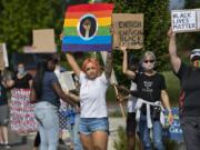 Kaitlyn Bruneau of Vancouver and other demonstrators gather to greet motorists outside Clark College on Wednesday afternoon.