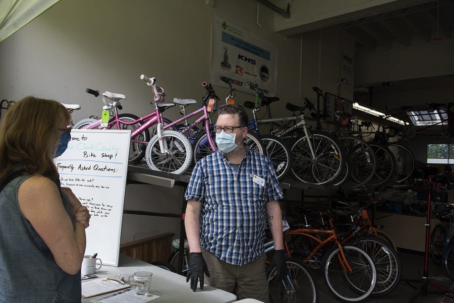 Vancouver resident Bev Warnock, left, talks with shop manager Eric Lien about repair for a bike at Bike Clark County on Wednesday morning. Bike sales have spiked during the COVID-19 pandemic.