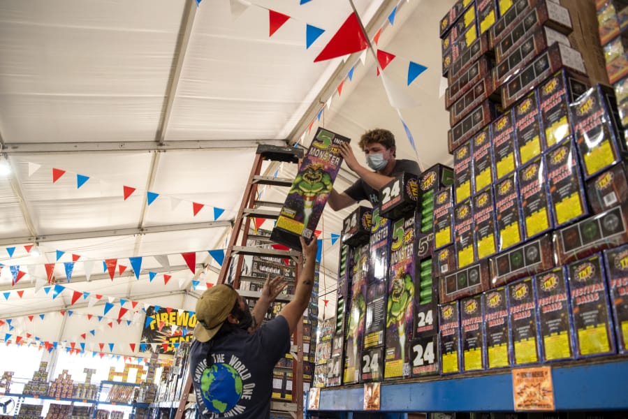 Assistant sales floor managers Cory Pena, left, and Skye Leach set up fireworks at TNT Fireworks Warehouse in Vancouver in June 2020.