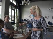 Trish Masters, from left, and George Gittelson of Vancouver try a taste from a bottle of Tuttorosso as associate Wynn Anderson pours a sample at Brian Carter Cellars on Wednesday. Wineries are open under Phase 2, and Brian Carter Cellars opened its doors for the first time on Wednesday.