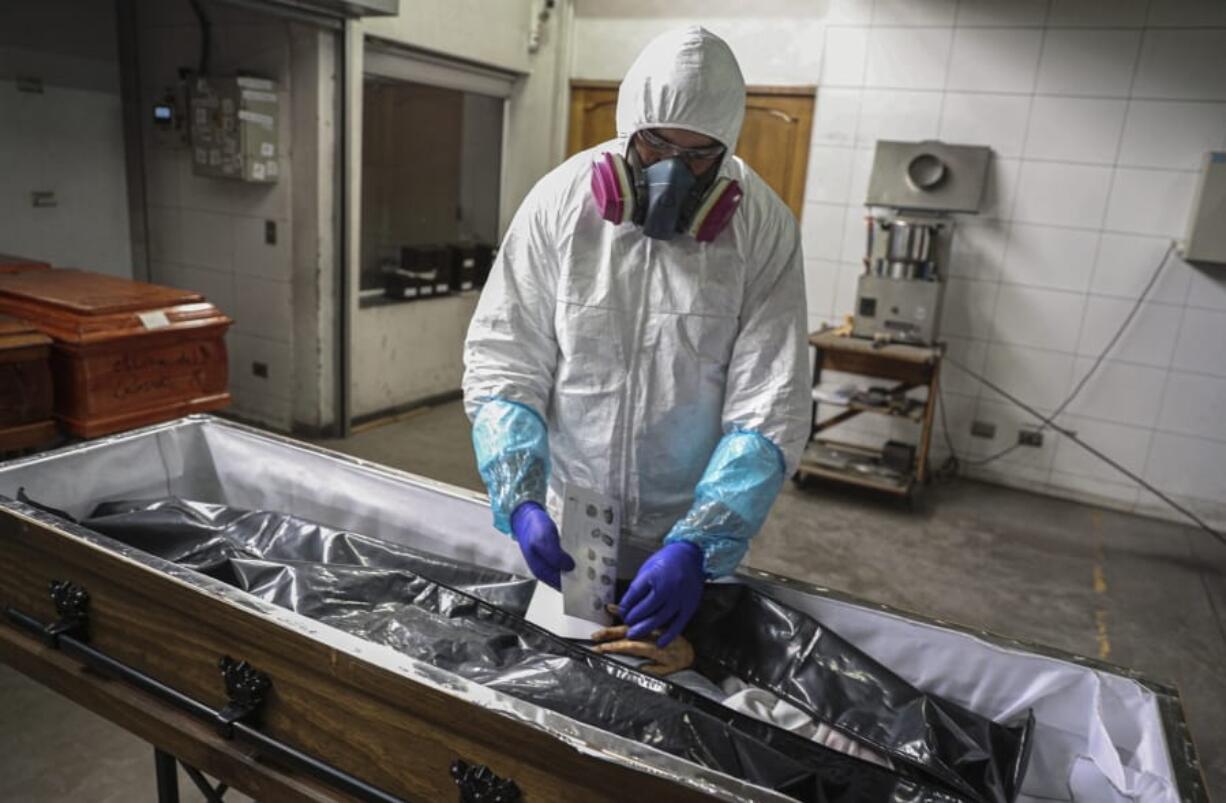 A worker wearing a protective suit swabs a man&#039;s throat for a coronavirus test at a community health clinic in Beijing, Sunday, June 28, 2020. China reported more than a dozen of new confirmed cases of COVID-19 on Sunday, all but a few of them from domestic transmission in Beijing, which has seen a recent spike in coronavirus infections. But authorities in the Chinese capital say a campaign to conduct tests on employees at hair and beauty salons across the city has found no positive cases so far, in a further sign that the recent outbreak has been largely brought under control.