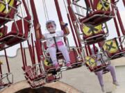 A young girl wearing a protective face shield enjoys a swing ride as physical distancing markings are seen on the seats during the first day of the reopening of Dunia Fantasi Amusement Park after weeks of closure due to the large-scale restrictions imposed to help curb the new coronavirus outbreak, at Ancol Dream Park in Jakarta, Indonesia, Saturday, June 20, 2020.