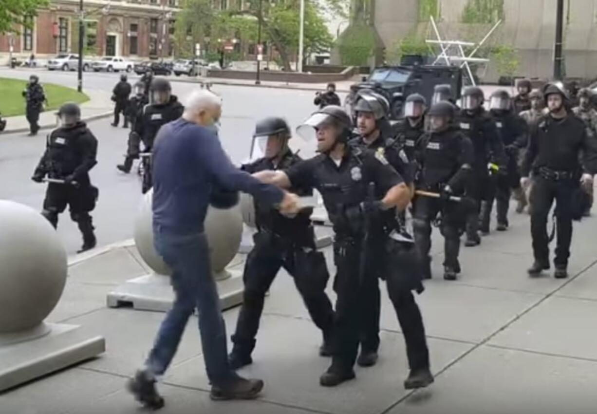 In this image from video provided by WBFO, a Buffalo police officer appears to shove a man who walked up to police Thursday, June 4, 2020, in Buffalo, N.Y. Video from WBFO shows the man appearing to hit his head on the pavement, with blood leaking out as officers walk past to clear Niagara Square. Buffalo police initially said in a statement that a person &quot;was injured when he tripped &amp; fell,&quot; WIVB-TV reported, but Capt. Jeff Rinaldo later told the TV station that an internal affairs investigation was opened. Police Commissioner Byron Lockwood suspended two officers late Thursday, the mayor&#039;s statement said.