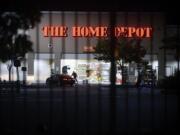 FILE - In this June 1, 2020, file photo, a man leaves a vandalized Home Depot store in Oakland, Calif. Police say many of the smash-and-grab thefts have been carried out by caravans of well-coordinated criminals that have coincided with or followed protests over the death of George Floyd, who was killed by a Minneapolis police officer who pressed his knee into Floyd&#039;s neck.