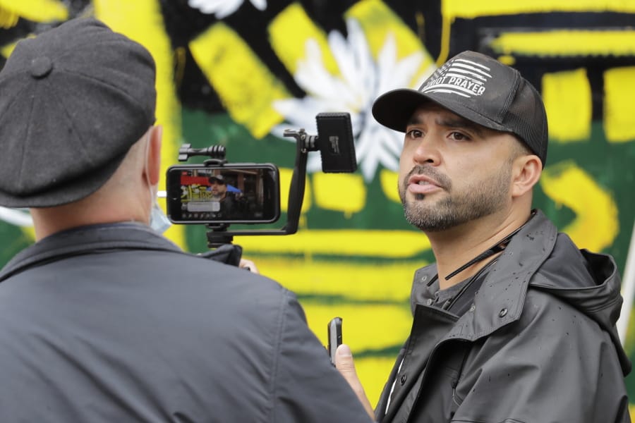 Joey Gibson, right, founder of the far-right group Patriot Prayer, takes part in a livestream video broadcast, inside what has been named the Capitol Hill Occupied Protest zone in Seattle, Monday, June 15, 2020.  (AP Photo/Ted S.