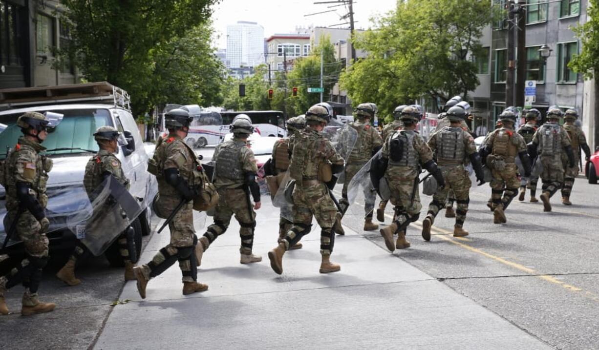 National Guard troops cross East Pike en route to the the East precinct of the Seattle Police Department, Monday, June 8, 2020, in Seattle&#039;s Capitol Hill neighborhood.