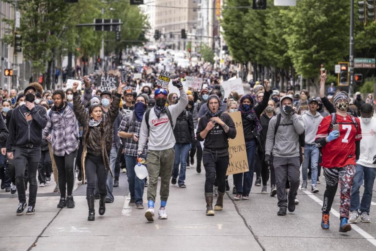 Protestors move south on 2nd Avenue in Seattle, Sunday, May 31, 2020, as demonstrations continue over the death of George Floyd. Floyd died after being restrained by Minneapolis police officers on May 25.