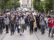 Protestors move south on 2nd Avenue in Seattle, Sunday, May 31, 2020, as demonstrations continue over the death of George Floyd. Floyd died after being restrained by Minneapolis police officers on May 25.