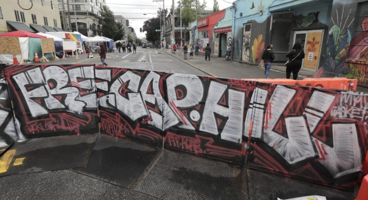 A sign at an entrance to what has been named the Capitol Hill Occupied Protest zone in Seattle reads &quot;Free Cap Hill,&quot; Monday, June 15, 2020. Protesters have taken over several blocks near downtown Seattle after officers withdrew from a police station in the area following violent confrontations. (AP Photo/Ted S.