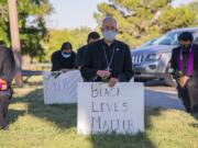 In this June 1, 2020, photo provided by the Catholic Diocese of El Paso, Bishop Mark Seitz, center, kneels with other demonstrators at Memorial Park holding a Black Lives Matter sign in El Paso, Texas. Pope Francis called Seitz unexpectedly after he was photographed at the protest.