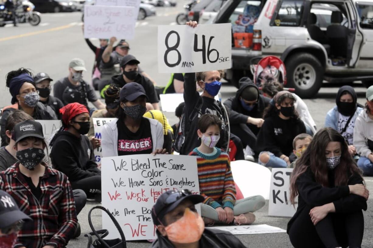 FILE - In this June 5, 2020, file photo, a protester holds a sign that reads &quot;8:46&quot; in Tacoma, Wash., during a protest against police brutality and the death of George Floyd, a black man who died after being restrained by Minneapolis police officers on May 25. Minnesota prosecutors acknowledged Wednesday, June 17, that a police officer had his knee on Floyd&#039;s neck for 7 minutes, 46 seconds, not the 8:46 that has become a symbol of police brutality. (AP Photo/Ted S.