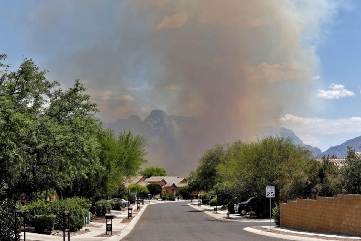 The Bighorn Fire backdrops a community along the western side of the Santa Catalina Mountains, Friday, June 12, 2020, in Tucson Ariz. Hundreds of homes on the outskirts of Tucson remain under an evacuation notice as firefighters work to keep the wildfire from moving downhill from canyons and ridges in the Coronado National Forest.