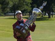 Daniel Berger poses with the championship trophy after winning the Charles Schwab Challenge golf tournament after a playoff round at the Colonial Country Club in Fort Worth, Texas, Sunday, June 14, 2020. (AP Photo/David J.