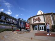 A visitor to the Pro Football Hall of Fame pauses to take a photo of the sign in front in Canton, Ohio. The NFL has canceled the 2020 Hall of Fame game that traditionally opens the preseason and is delaying the 2020 induction ceremonies because of the coronavirus pandemic. (AP Photo/Gene J.