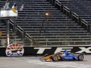 Scott Dixon earns the checkered flag as he crosses the finish line to win an IndyCar auto race at Texas Motor Speedway in Fort Worth, Texas, Saturday, June 6, 2020.