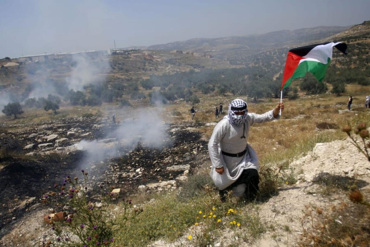 Palestinians run away from tear gas fired by Israeli soldiers during a protest against Israel&#039;s plan to annex parts of the West Bank and Trump&#039;s mideast initiative ,in the West Bank village of Qusin near Nablus Friday, Jun.