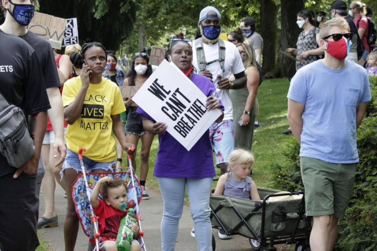 Katrina Hendricks, left, pushes a stroller holding her son, Melo, as her mother, Elaine Loving, walks alongside her at a Juneteenth rally and march Friday in Portland. Loving has lived in the same house in a North Portland neighborhood since her birth in 1959, but says many Black families have moved away as gentrification has occurred.