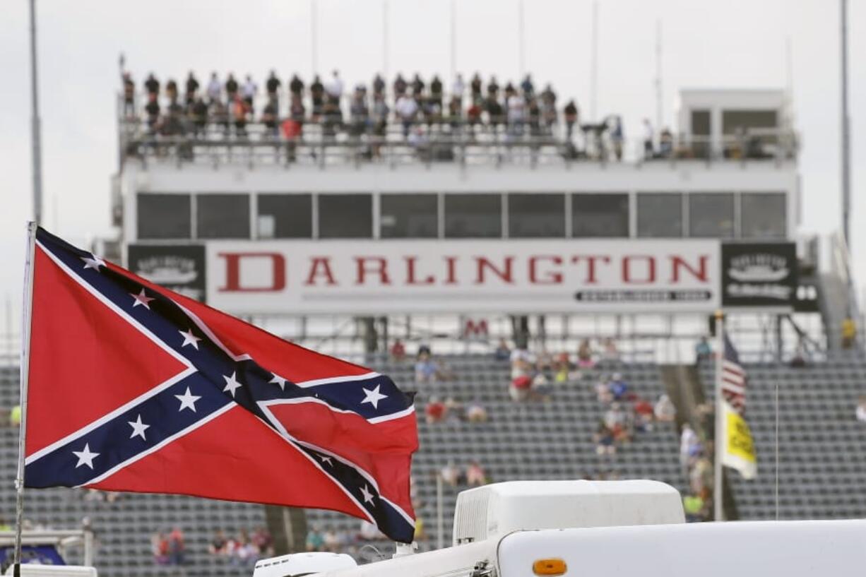 FILE - In this Sept. 5, 2015, file photo, a Confederate flag flies in the infield before a NASCAR Xfinity auto race at Darlington Raceway in Darlington, S.C. Bubba Wallace, the only African-American driver in the top tier of NASCAR, calls for a ban on the Confederate flag in the sport that is deeply rooted in the South.