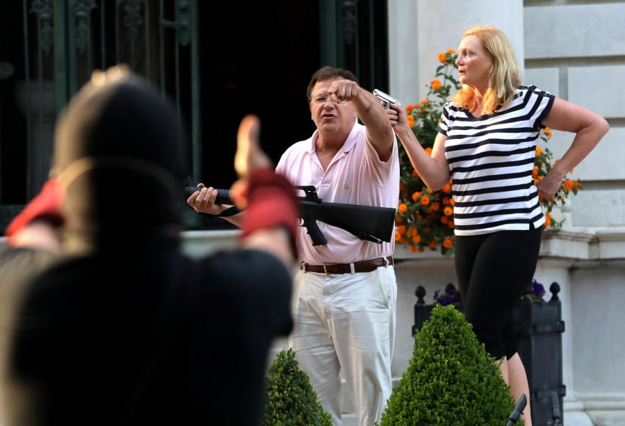 Armed homeowners standing in front their house along Portland Place confront protesters marching to St. Louis Mayor Lyda Krewson&#039;s house Sunday, June 28, 2020, in the Central West End of St. Louis. The protesters called for Krewson&#039;s resignation for releasing the names and addresses of residents who suggested defunding the police department. (Laurie Skrivan/St.