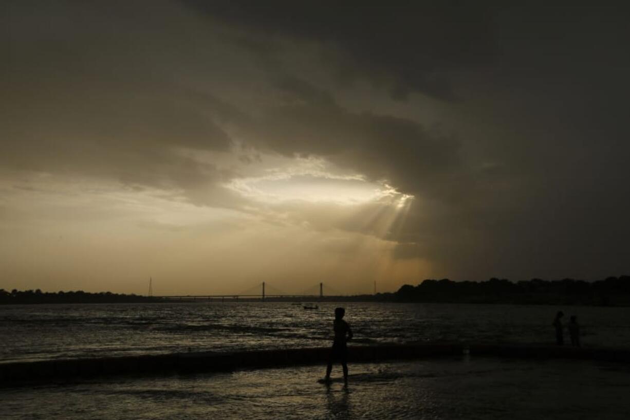 FILE - In this Wednesday, May 27, 2020 file photo, a boy stands on the shore of the Ganges River during a hot summer day in Prayagraj, India. Earth&#039;s temperature spiked to tie a record high for May, the U.S. National Oceanic and Atmospheric Administration reported on Friday, June 12, 2020. The global land temperature was the hottest for May on record. The heat was especially extreme in  Siberia, Alaska, Asia, along the equator, the Southern Hemisphere and parts of the Northern Pacific Ocean.