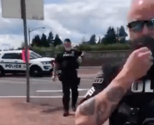 A screen grab from a video posted to Facebook shows Ridgefield police officers talking to protester John Tudor. Tudor was cited for disorderly conduct.