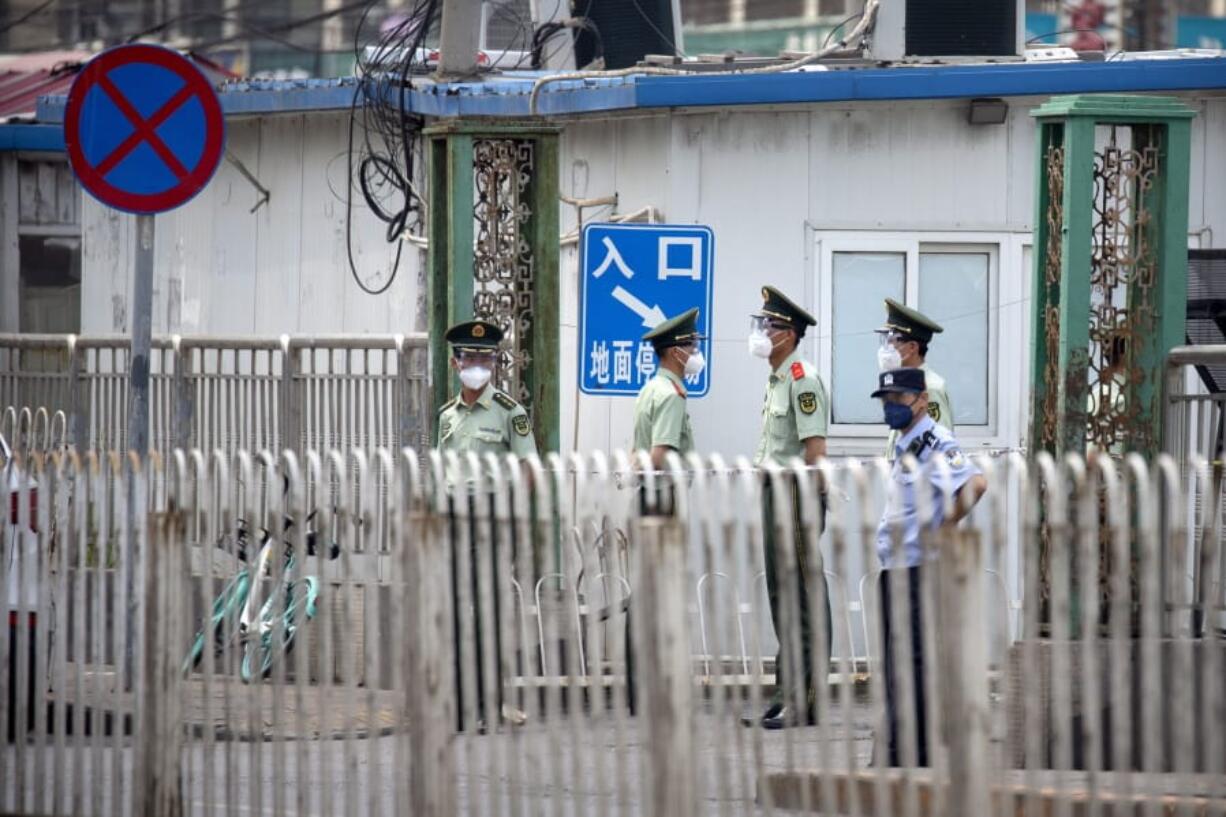 Paramilitary police stand guard on a street near the Xinfadi wholesale food market district in Beijing, Saturday, June 13, 2020. Beijing closed the city&#039;s largest wholesale food market Saturday after the discovery of seven cases of the new coronavirus in the previous two days.