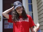 In this June 1, 2020 photo, high school graduate Lizzie Quinlivan wears a Georgetown University cap at her home in Hingham, Mass. Quinlivan has opted to attend closer-to-home Georgetown instead of colleges on the west coast which were on her original wish-list. As students make college plans for this fall, some U.S. universities are seeing surging interest from in-state students looking to stay closer to home amid the coronavirus pandemic.