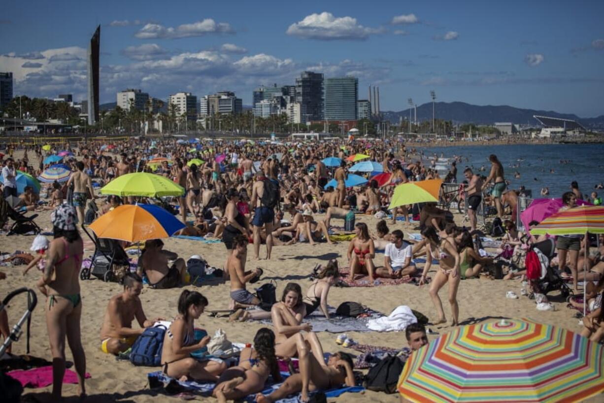 FILE - In this Saturday, June 13, 2020 file photo, people enjoy the warm weather on the beach in Barcelona, Spain. European Union envoys are close to finalizing a list of countries whose citizens will be allowed back into Europe once it begins lifting coronavirus-linked restrictions. The United States appears almost certain not to make the list, as new infections surge and given that President Donald Trump has imposed a ban on European travelers.