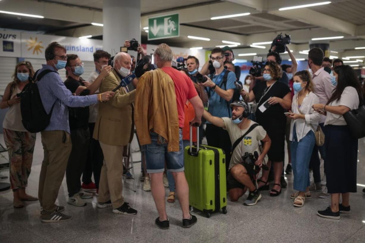 A TUI X3 2312 Duesseldorf-Mallorca flight passenger talks to the press at Son Sant Joan airport in Palma de Mallorca, Spain, Monday, June 15, 2020. Whether its German holidaymakers basking in Spain&#039;s sunshine or Parisians renewing their love affair with their city, Monday&#039;s border openings and further scrapping of restrictions offered Europeans a taste of pre-coronavirus life that they may have taken for granted.